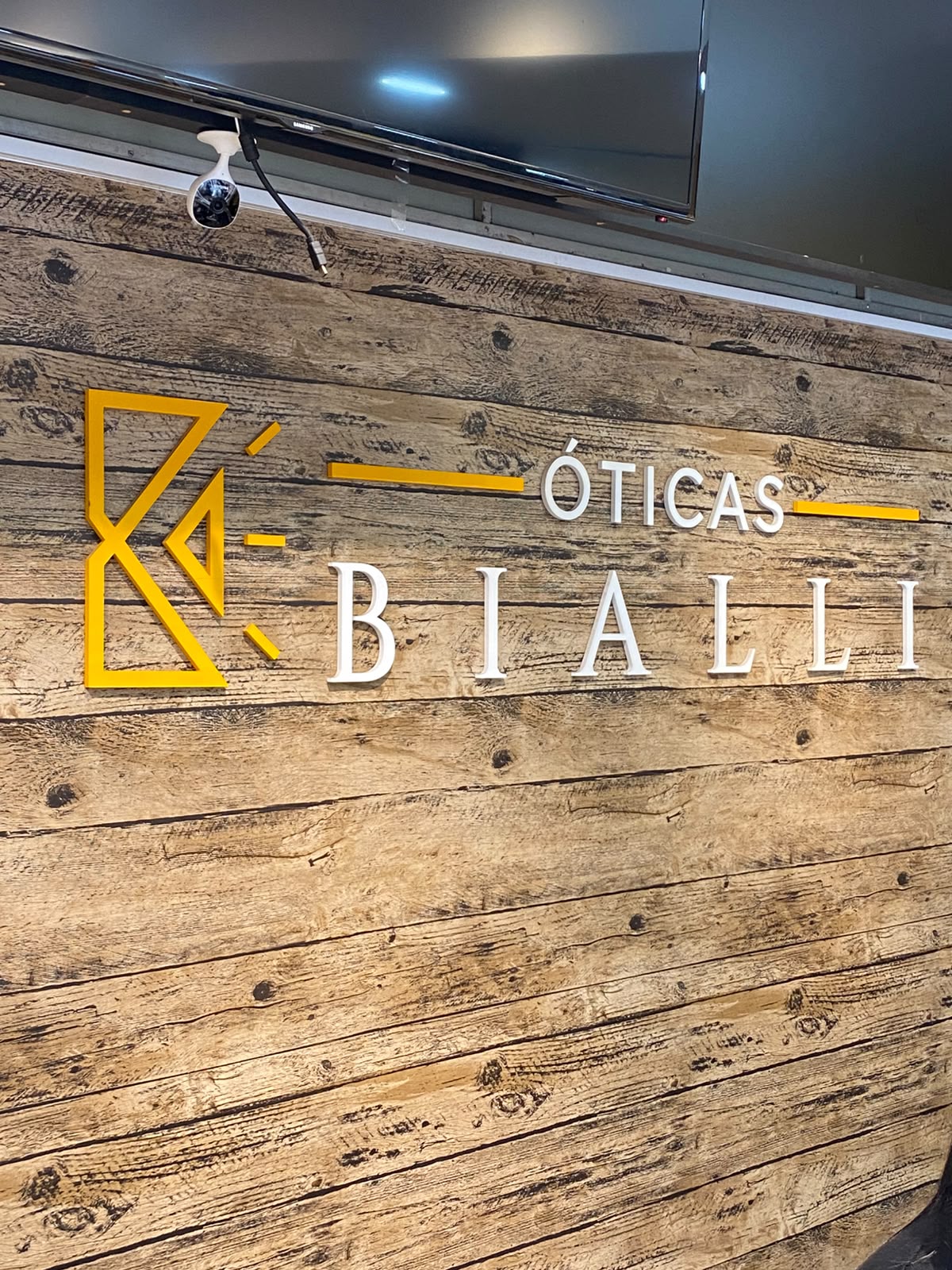 Painel sofisticado da Óticas Bialli em madeira de alta qualidade